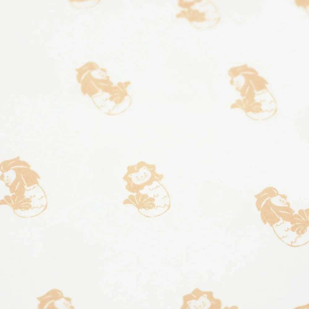 A close-up of an orange Merlion print of a white baby romper from Le Petit Society.