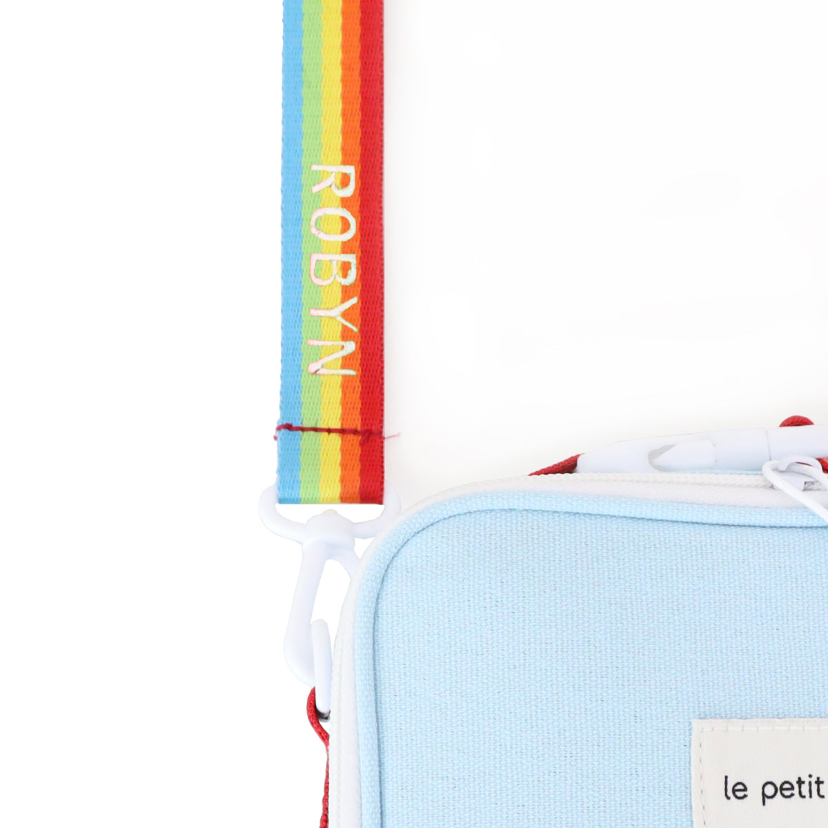A close-up of a personalised name embroidery on a rainbow bag strap of a thermal lunch bag from Le Petit Society.