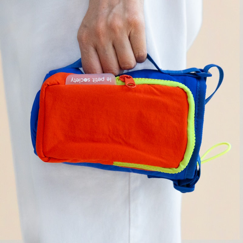 A hand carrying a water bottle bag with a side handle