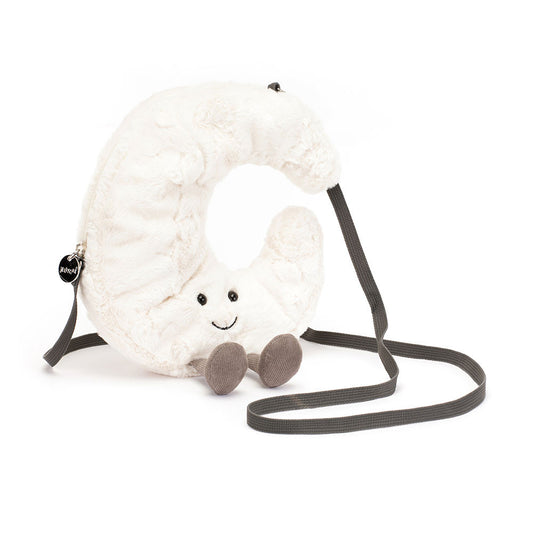 A front view of a soft plush crescent moon-shaped crossbody bag with a smiling face, black bead eyes, brown corduroy legs, and a long dark gray strap.
