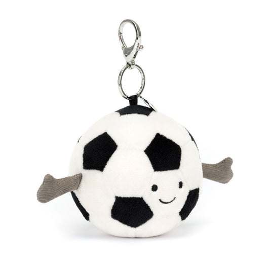 A front view of a plush soccer ball keychain with a smiling face and soft gray arms, featuring a black and white pattern and metal clip.