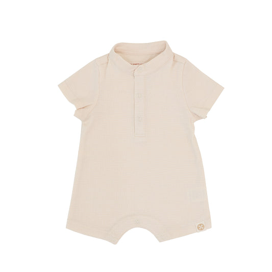 A baby boy romper in an oat-coloured, rib knit material from Le Petit Society.