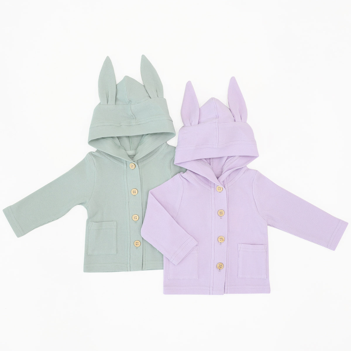 A pair of baby cardigan with bunny ears on the hood. They are made with waffle jersey and come in sage green and lilac purple respectively. 