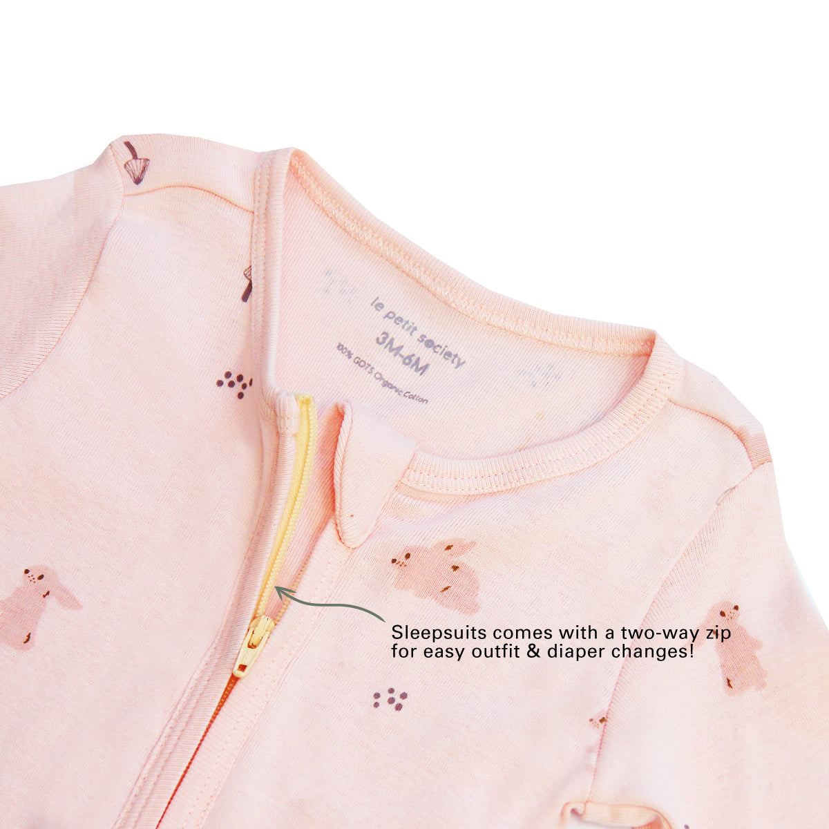 An infographic demonstrating the two-way zipper of a pink baby zip sleepsuit, and its function of providing an easy access to outfit and diaper changes.
