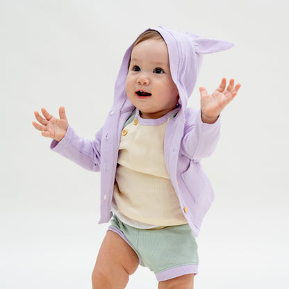 A baby boy wearing a set of boxers and raglan tee in a matching pastel colour scheme