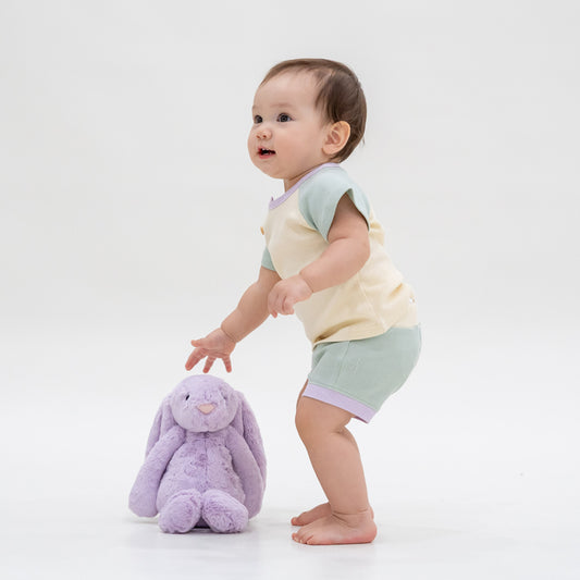A baby wearing a matching set of waffle jersey boxers and raglan tee in a colour block.