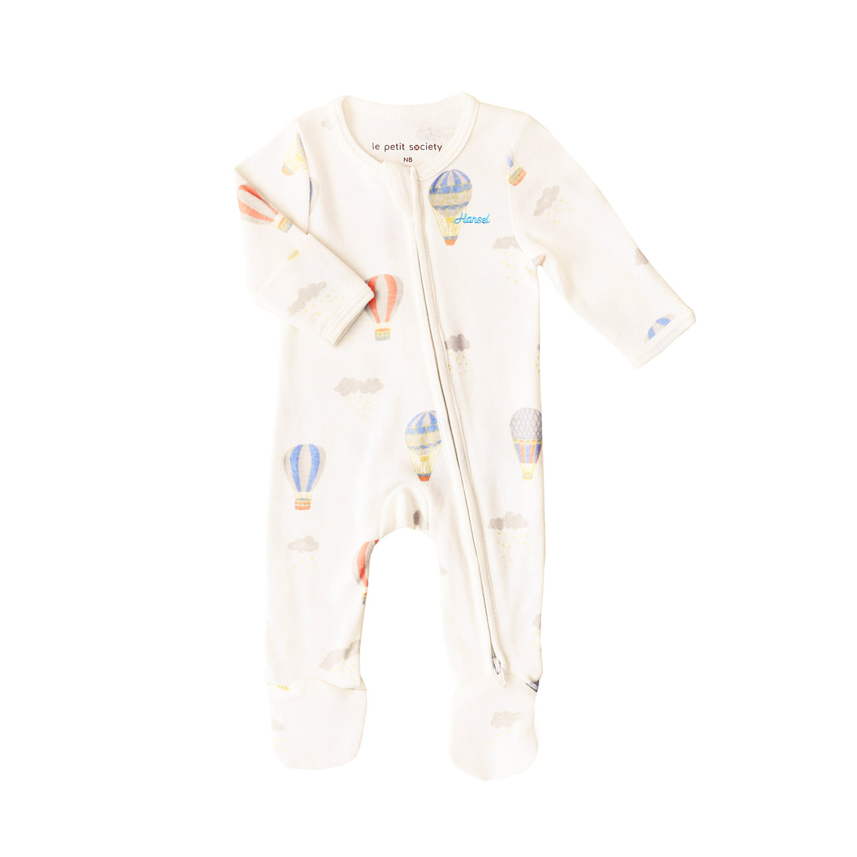 An organic baby zip sleepsuit from Le Petit Society. It is beige in colour with a print of hot air balloons and foldable mittens and footies.