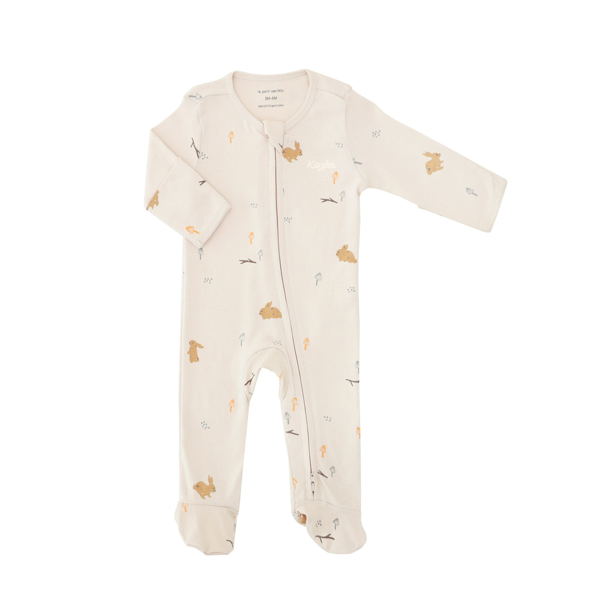 A baby organic zip sleepsuit with foldable mittens and footies by Le Petit Society, featuring a woodland-themed motif with rabbits over a beige base. 