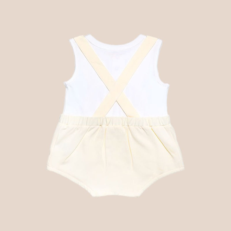 An animal-themed baby romper by Le Petit Society, featuring a sheep's face in beige at the front, complete with bottoms and cross back straps in beige over a white undershirt.