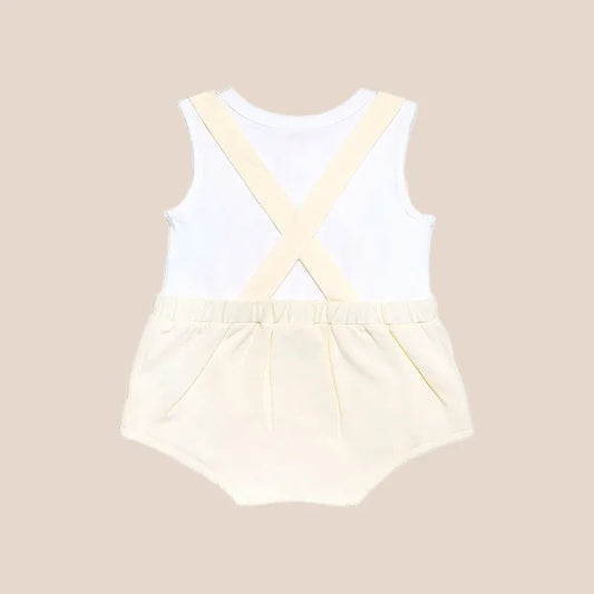 An animal-themed baby romper by Le Petit Society, featuring a sheep's face in beige at the front, complete with bottoms and cross back straps in beige over a white undershirt.