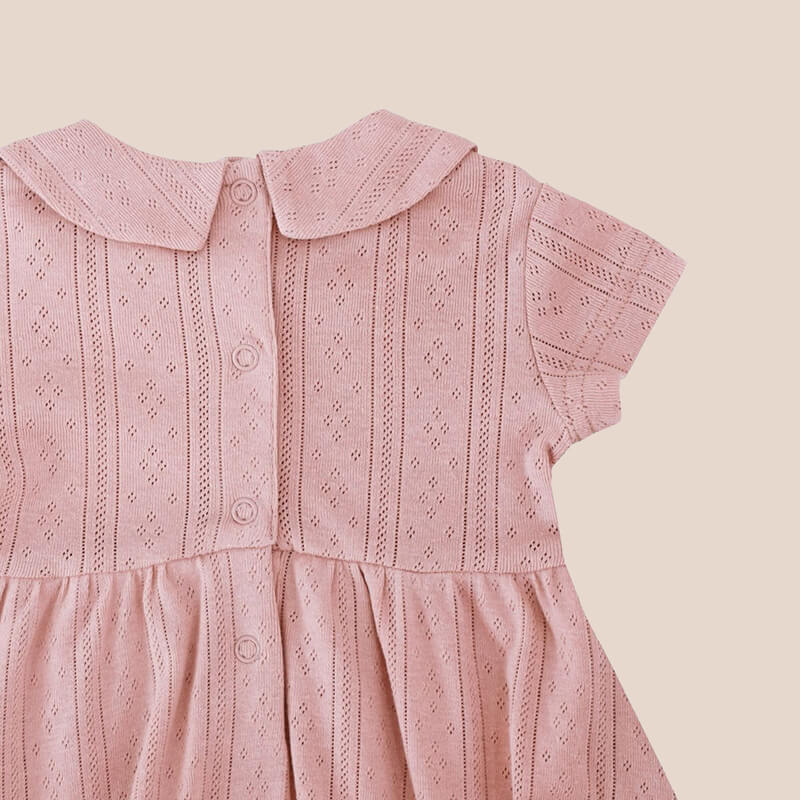 A plum-coloured, pointelle cotton dress with a peter pan collar from Le Petit Society. It also comes with snap buttons at the back for easy changing.