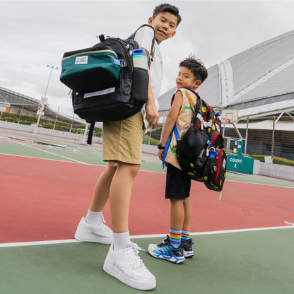 Two primary school boys carrying the essential school bundles from Le Petit Society.
