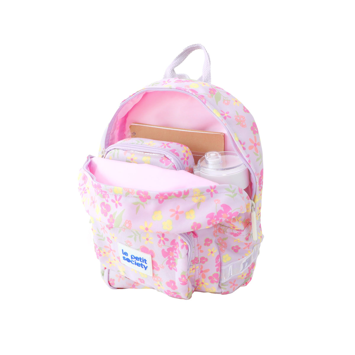 A water bottle, pencil case and notebook stored in a purple preschool bag with floral print.