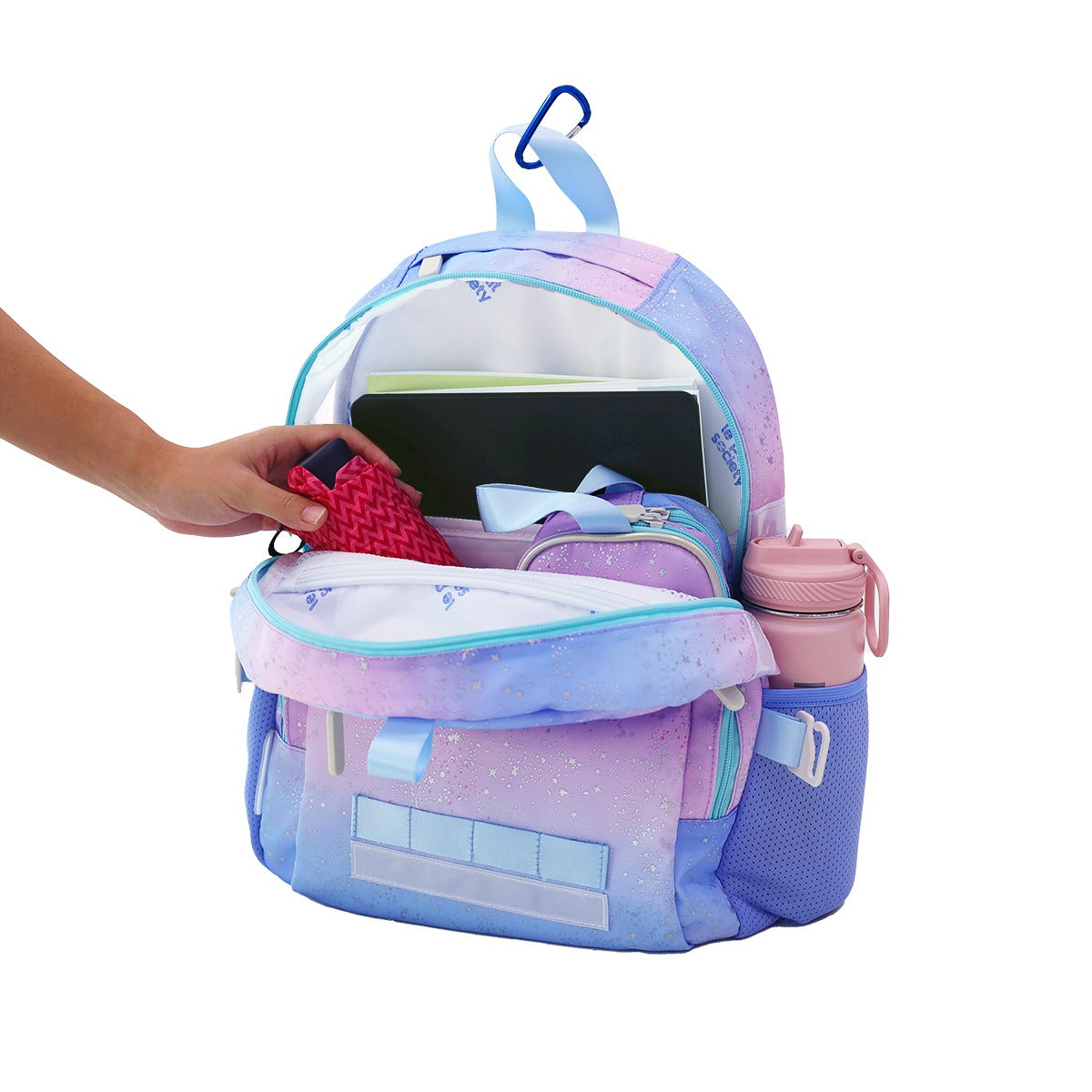 An umbrella, pencil case and several notebooks being stored in the kids single pocket school bag.