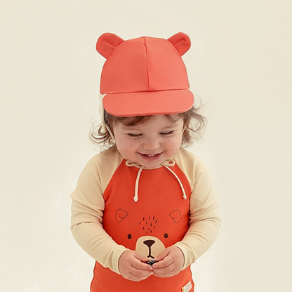 Baby Girl in Le Petit Society Baby Orange Bear Swimsuit Front 