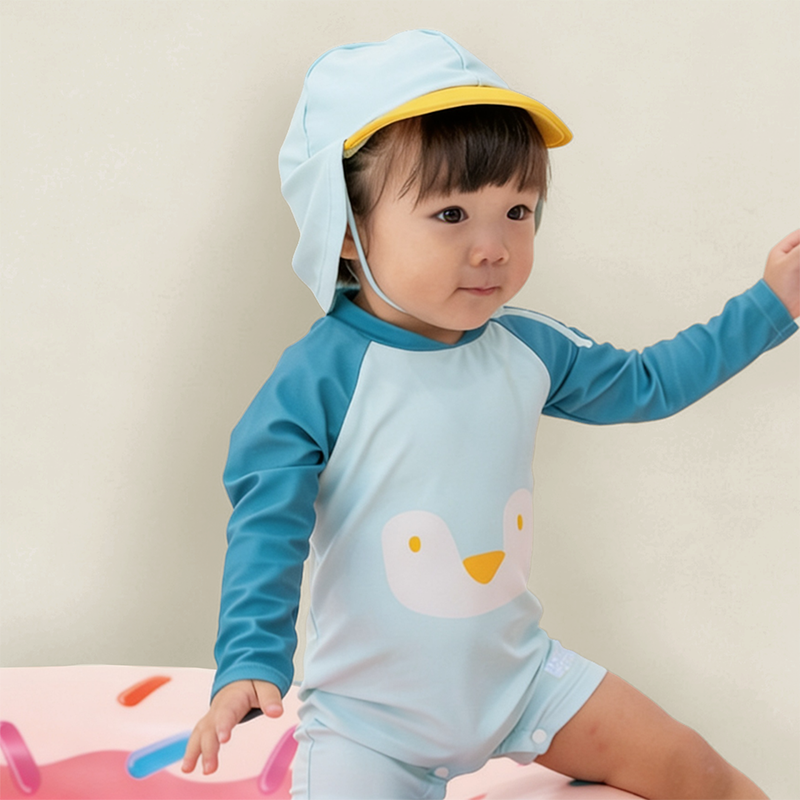 Baby Girl in Le Petit Society Blue Penguin Swimsuit Lifestyle Shot