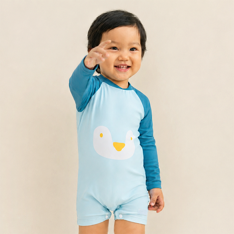 Baby Boy in Le Petit Society Blue Penguin Swimsuit 