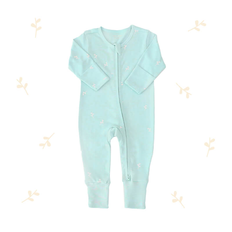 An organic baby zip sleepsuit from Le Petit Society. It is mint blue in colour, with a print of leaves and foldable mittens and footies.