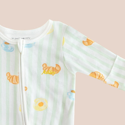 A close-up of a name embroidery personalisation on a baby bamboo sleepsuit in breakfast print by Le Petit Society.