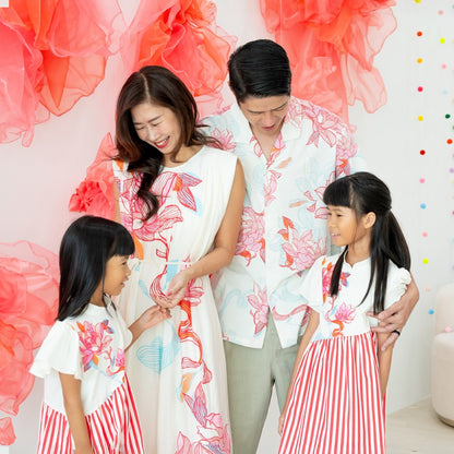 This sweet family moment shows off the full Le Petit Society x Sheila Sim CNY 2026 Lotus Collection. Mum wears the elegant lotus-print dress, Dad is in the matching men’s shirt, and the girls twirl in their lotus-and-stripe cheongsam dresses. The soft cor
