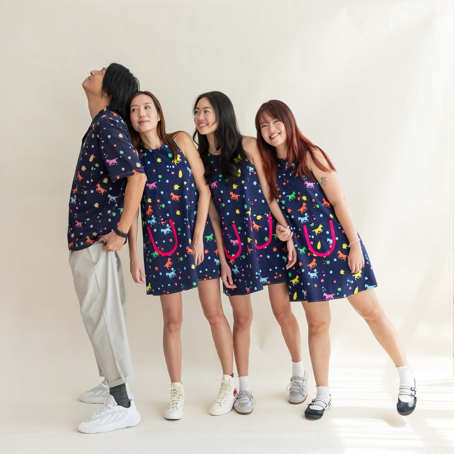 Four women wearing dresses and a man wearing a matching shirt from the Le Petit Society x Sheila Sim CNY 2026 Rainbow Horse Collection, posing playfully together.