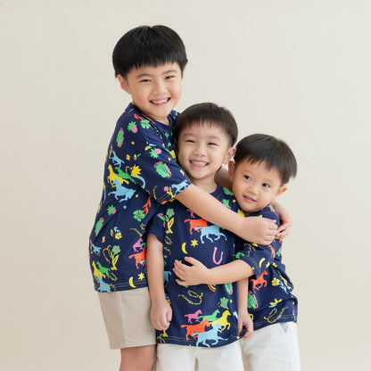 Three boys huddle close in a warm group hug, all wearing matching Rainbow Horse tees. Their big smiles and coordinated outfits create a sweet, festive moment full of sibling charm.
