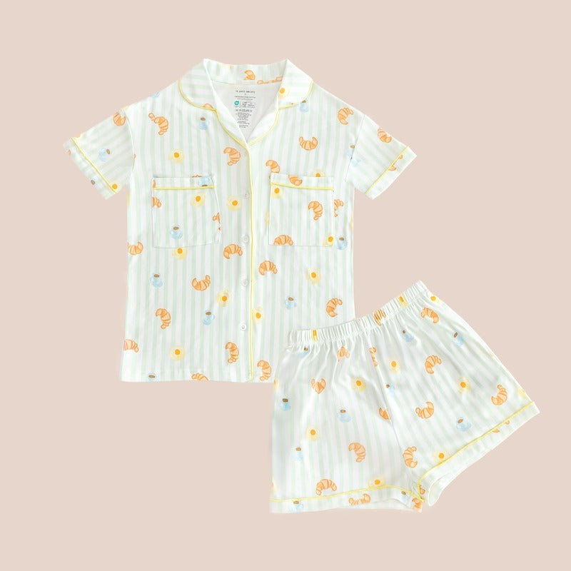 A ladies bamboo pyjamas set from Le Petit Society, featuring a print of breakfast food and pastel green stripes.