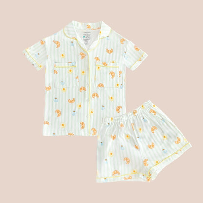 A ladies bamboo pyjamas set from Le Petit Society, featuring a print of breakfast food and pastel green stripes.