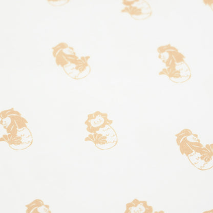 A close-up of an orange Merlion print of a white baby romper from Le Petit Society.