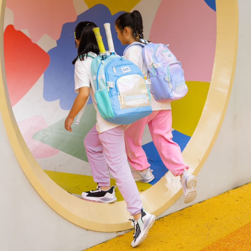 Two primary schoolers carrying the single pocket school bags from Le Petit Society.