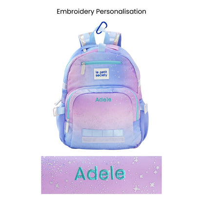 The single pocket kids school bag with an ombre, metallic galaxy design and a personalised name embroidery at the front.