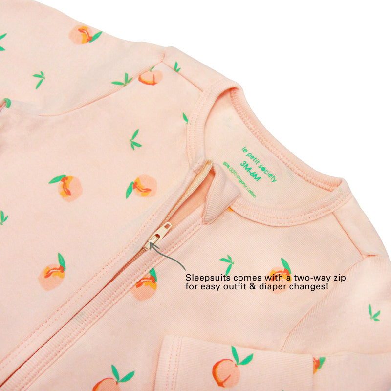 An infographic demonstrating the two-way zipper of a coral pink baby zip sleepsuit, and its function of providing an easy access to outfit and diaper changes.