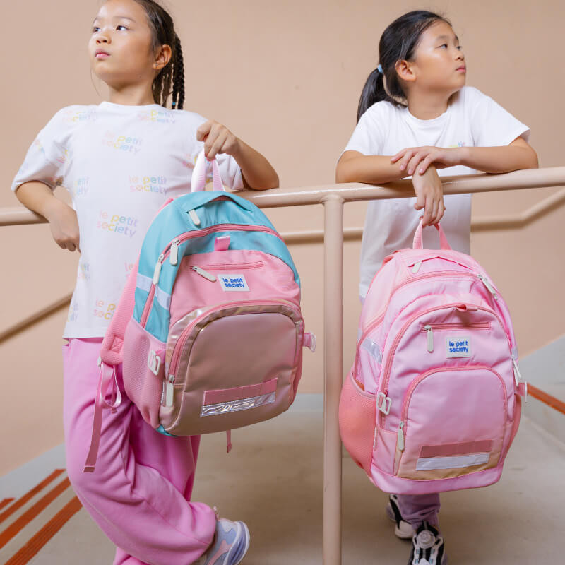 Two primary school girls carrying the kids single pocket school bag from Le Petit Society.