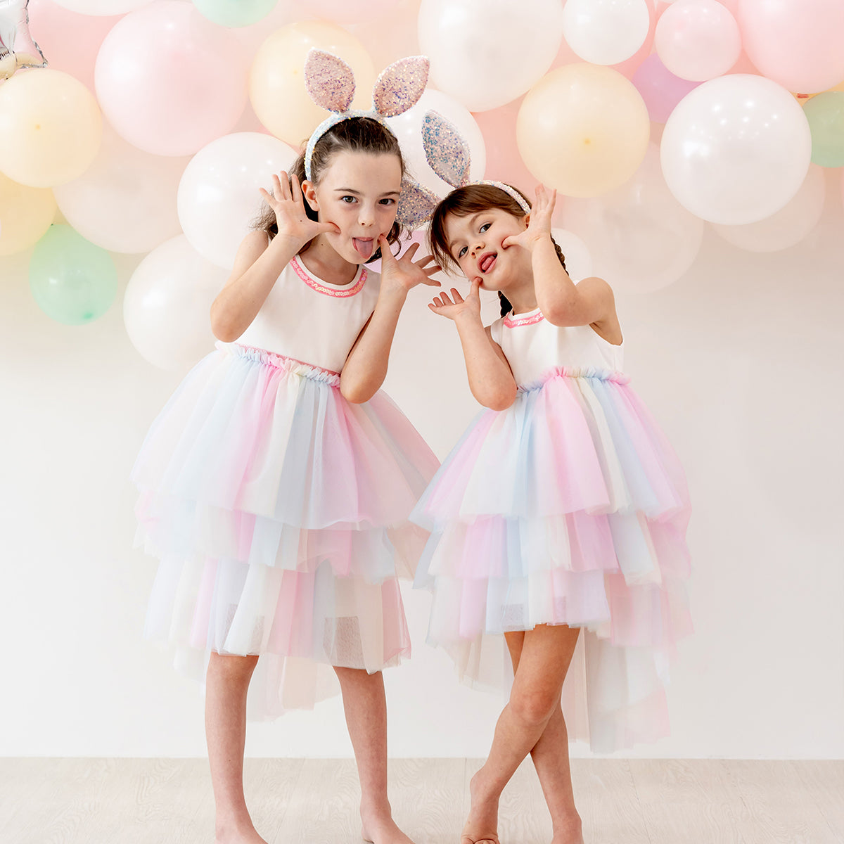 Flower girl cascading dress with layered rainbow tulle skirt and sequin trim at the neckline