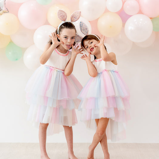 Flower girl cascading dress with layered rainbow tulle skirt and sequin trim at the neckline
