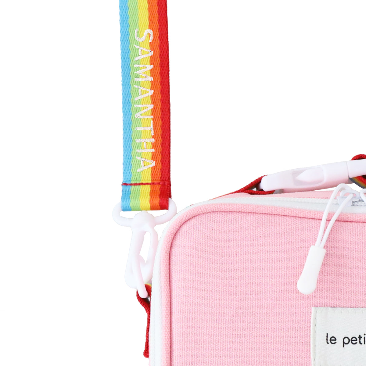 A close-up of a personalised name embroidery on a rainbow bag strap of a thermal lunch bag from Le Petit Society.