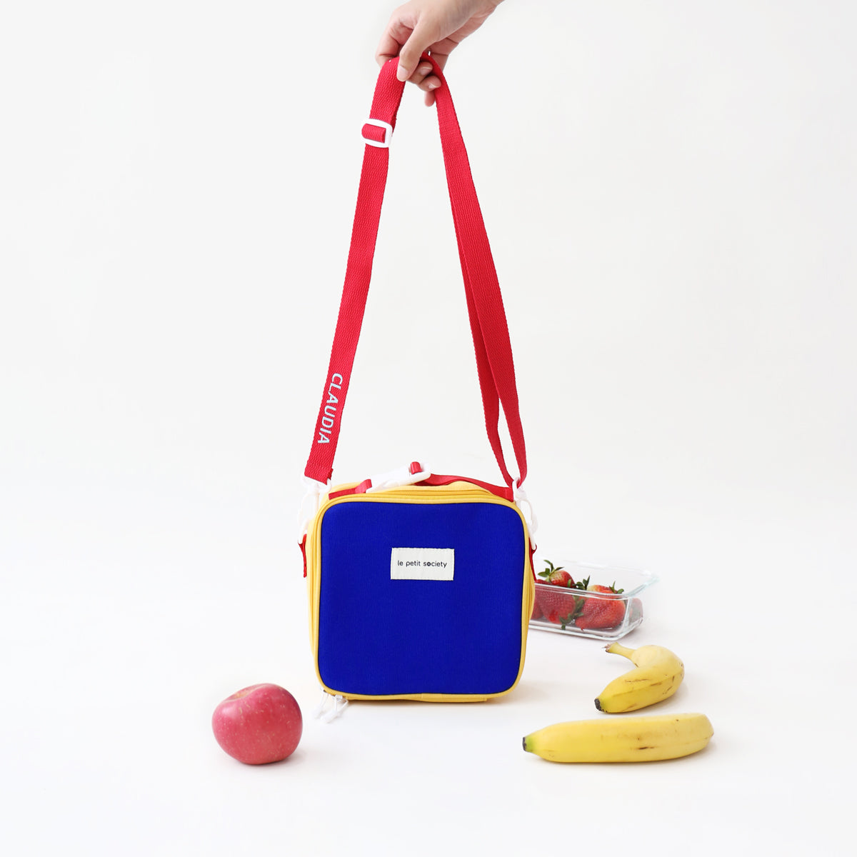 Le Petit Society's colour block thermal lunch bag comes with an adjustable strap.
