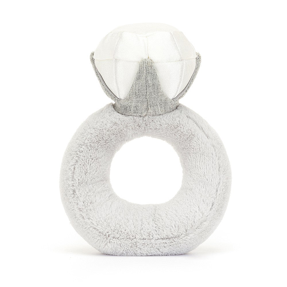 A back view of a soft, plush toy shaped like an engagement ring, with a smiling face and sparkly diamond on top. The light gray fabric gives it a cute, endearing design, perfect for babies or as a decorative piece.
