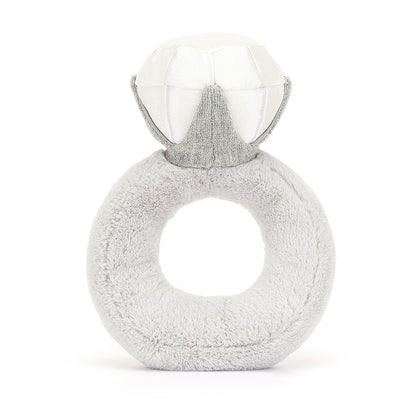 A back view of a soft, plush toy shaped like an engagement ring, with a smiling face and sparkly diamond on top. The light gray fabric gives it a cute, endearing design, perfect for babies or as a decorative piece.