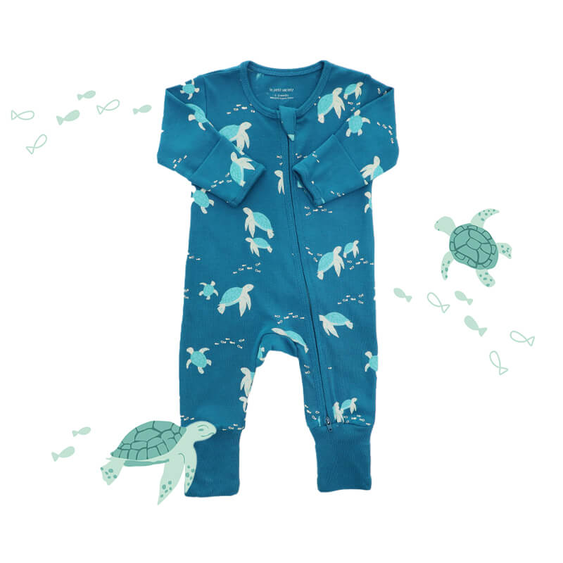 An organic baby zip sleepsuit from Le Petit Society. It is blue in colour with a print of turtles and foldable mittens and footies.