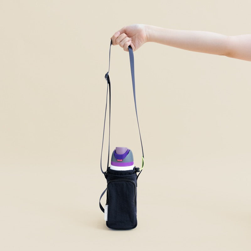 A hand holding on to the adjustable strap of a water bottle sling bag 