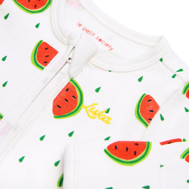 A close-up of a name embroidery personalisation on a baby zip sleepsuit with a watermelon print
